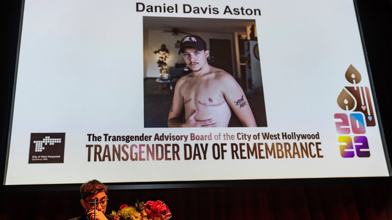 Musician Ryan Cassata reads the name of 28-year-old victim Daniel Davis Aston, a bartender killed at Club Q in Colorado Springs, Colo., at the Transgender Day of Remembrance event in West Hollywood, Calif., Sunday night, Nov. 20, 2022. (AP Photo/Damian Dovarganes)