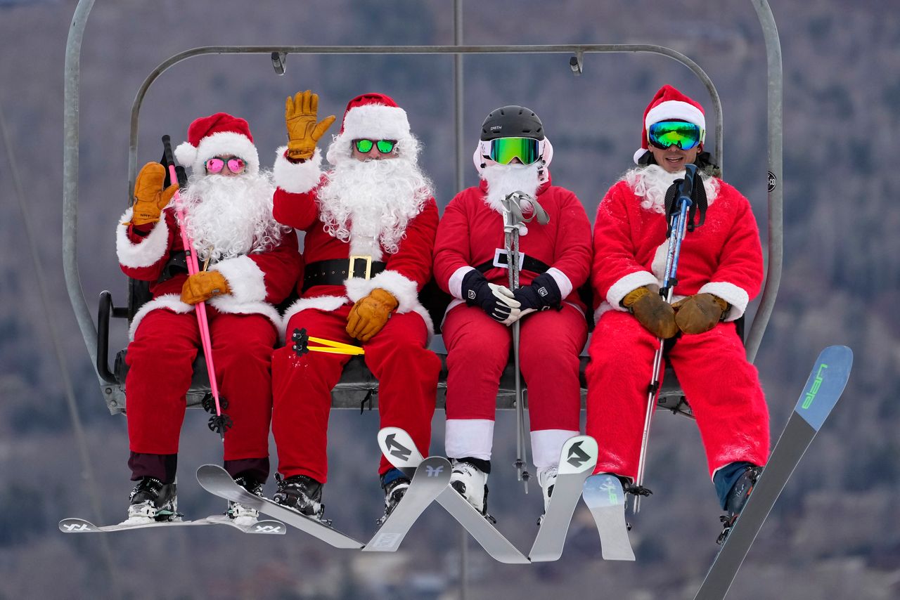 Skiers dressed in Santa Claus outfits ride a chairlift at the Sunday River Ski Resort, Sunday, Dec. 11, 2022, in Newry, Maine. The skiing Santas raise money for the River Fund, a non-profit organization that supports youth education and recreation in the Bethel, Maine area. (AP Photo/Robert F. Bukaty)