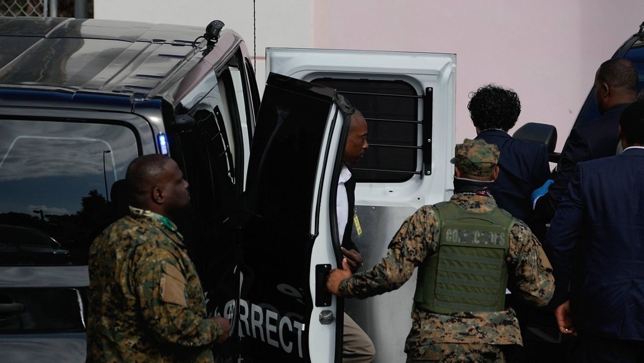 FTX founder Sam Bankman-Fried, top right, is escorted from a corrections van into the Magistrate Court in Nassau, Bahamas, Monday, Dec. 19, 2022. (AP Photo/Rebecca Blackwell)