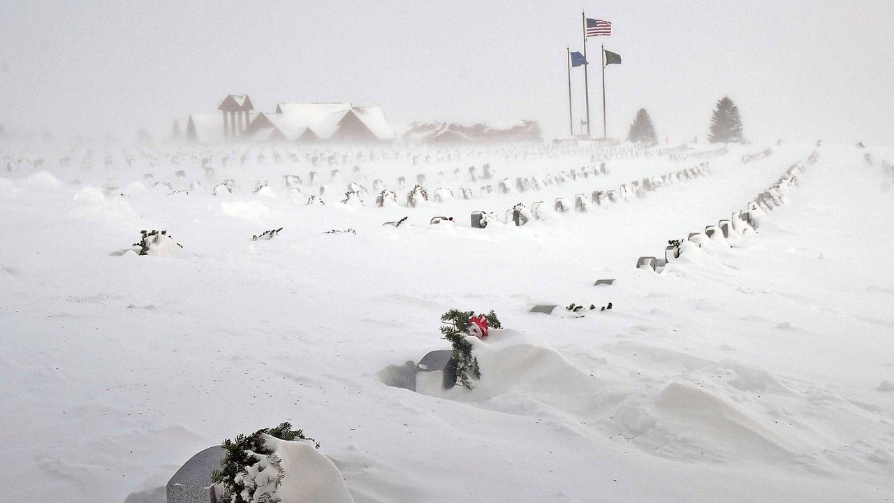 Rows of headstones at the North Dakota Veterans Cemetery are blanketed by drifting snow Thursday, Dec. 22, 2022, in Mandan, N.D. (Tom Stromme/The Bismarck Tribune via AP)