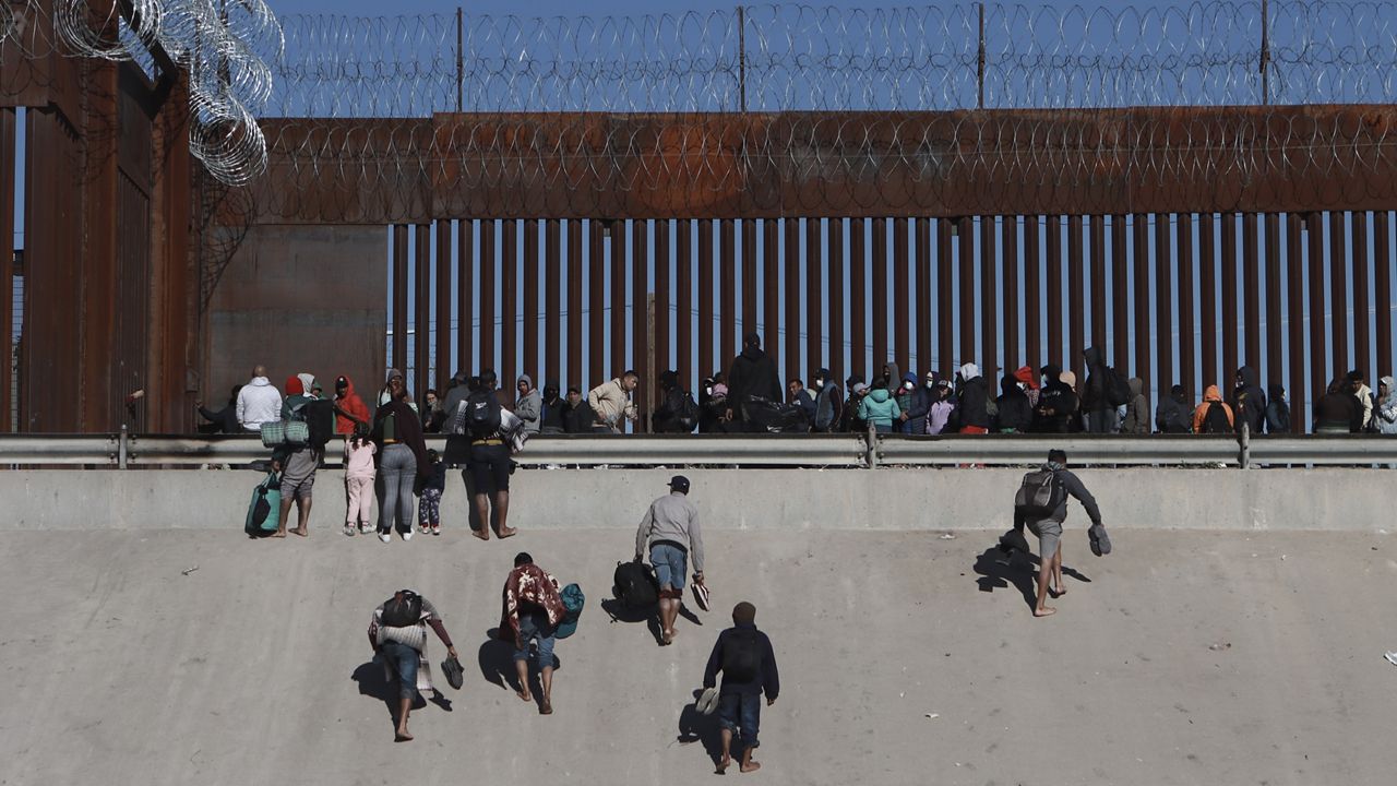 Migrants approach the border wall in Ciudad Juarez, Mexico, Dec. 21, 2022, on the other side of the border from El Paso, Texas. President Joe Biden is heading to the U.S.-Mexico border on Sunday, Jan. 8, 2023, for his first visit as president. Biden will stop in El Paso, currently the biggest corridor for illegal crossings. (AP Photo/Christian Chavez, File)
