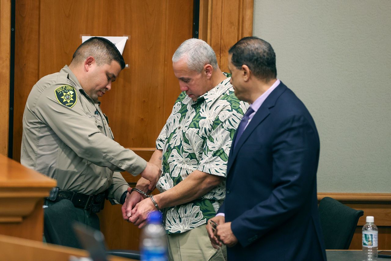 A court officer removes Albert "Ian" Schweitzer's handcuffs following the judge's decision to release him from prison immediately after his attorneys presented new evidence at a hearing Tuesday, Jan. 24, 2023, in Hilo, Hawaii and argued that he didn’t commit the crimes he was convicted of and spent more than 20 years locked up for: the 1991 murder, kidnapping and sexual assault of a woman visiting Hawaii. (Marco Garcia/The Innocence Project via AP Images)