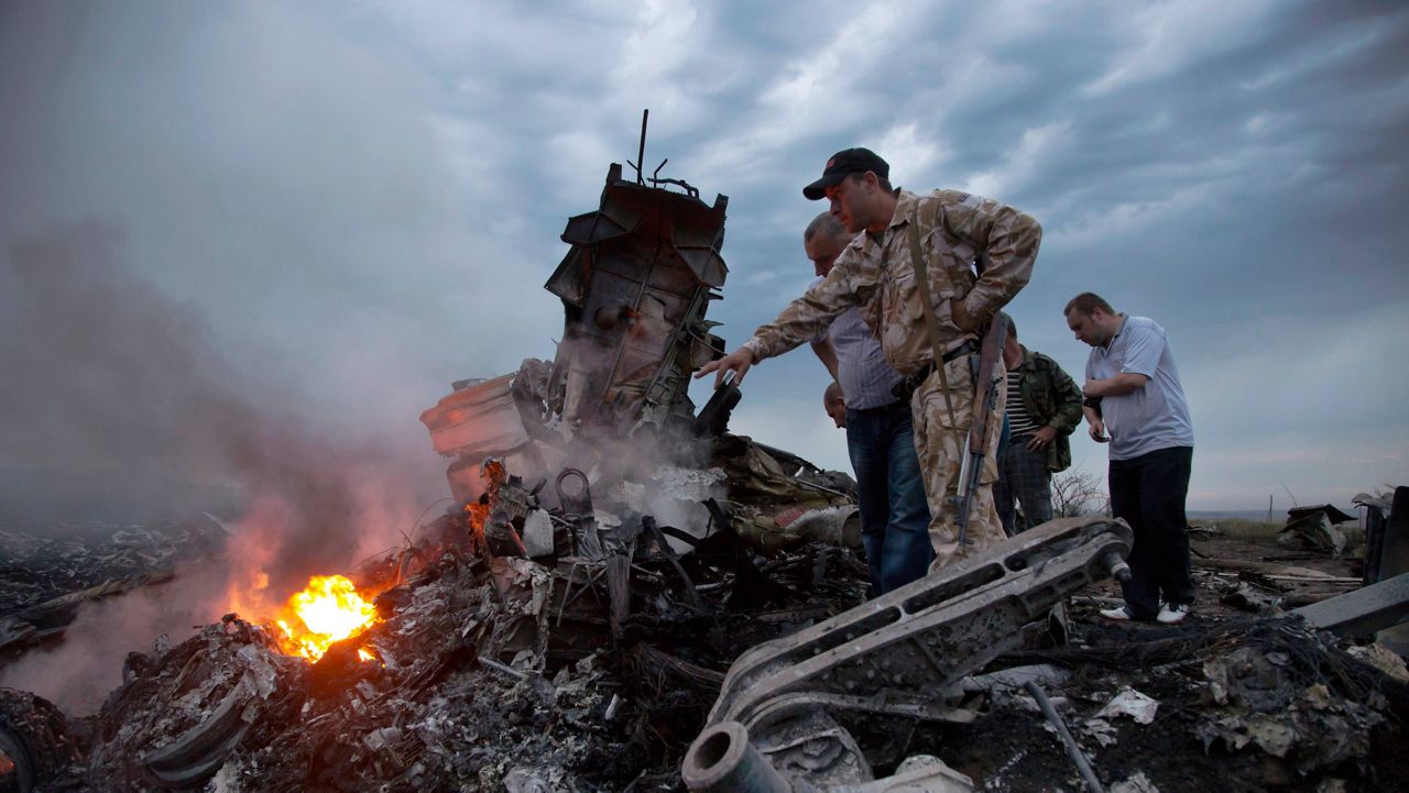 People inspect the crash site of a passenger plane near the village of Hrabove, Russian-controlled Donetsk region of Ukraine on Thursday, July 17, 2014. Europe's top human rights court ruled Wednesday, Jan. 25, 2023 that it can adjudicate on cases brought by the Netherlands and Ukraine against Russia for alleged rights violations in eastern Ukraine in 2014, including the downing of Malaysia Airlines flight MH17. (AP Photo/Dmitry Lovetsky)