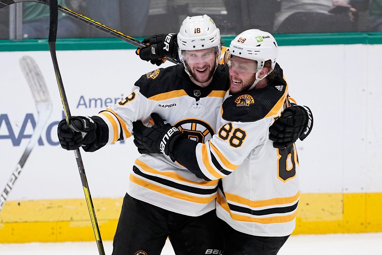 Boston Bruins' Pavel Zacha (18) and David Pastrnak (88) celebrate after Zacha scored in the third period of an NHL hockey game against the Dallas Stars, Tuesday, Feb. 14, 2023, in Dallas. (AP Photo/Tony Gutierrez)
