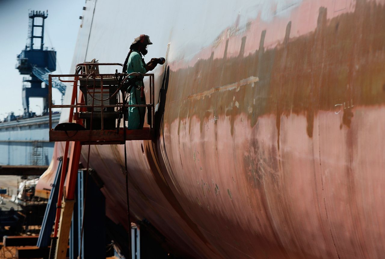 FILE — Welder Neal Larsen works on the hull of a Zumwalt-class destroyer Aug. 29, 2018, being built in the shipyard at Bath Iron Works in Bath, Maine. The U.S. Navy, following costly lessons after cramming too much new technology onto warships and speeding them into production, is slowing down the design and purchase of its next-generation destroyer, and taking extra steps to ensure new technology like lasers and hypersonic missiles have matured before pressing ahead. (AP Photo/Robert F. Bukaty, File)