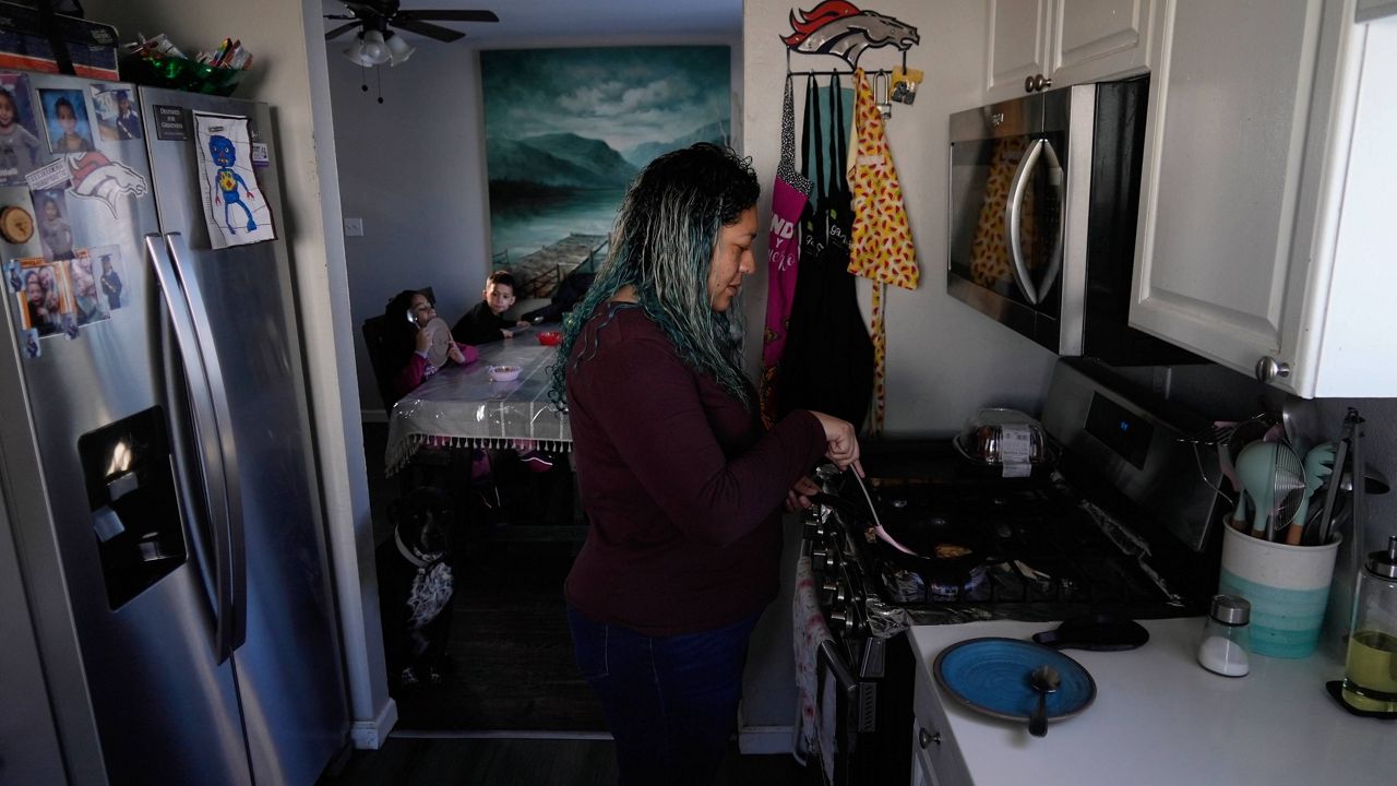Betty Rivas prepares breakfast for her family Thursday, Feb. 23, 2023, in Commerce City, Colo. Rivas was startled by a letter telling her that the drinking fountains her 8-year-old used at school weren't safe. PFAS stories had been in the local news and the school district told families to use bottled water. (AP Photo/Brittany Peterson)