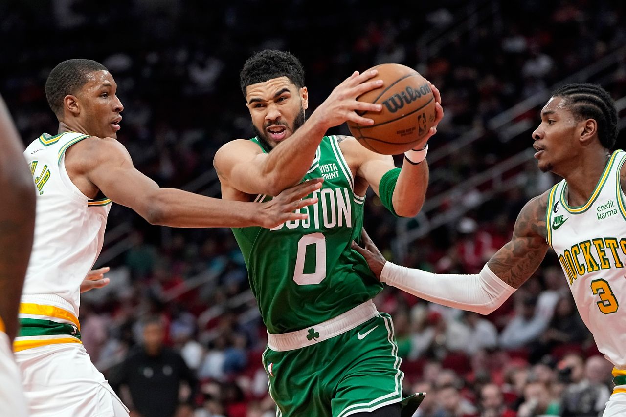 Boston Celtics' Jayson Tatum (0) drives to the basket as Houston Rockets' Kevin Porter Jr. (3) and Jabari Smith Jr. defend on Monday, March 13, in Houston. (AP Photo/David J. Phillip)