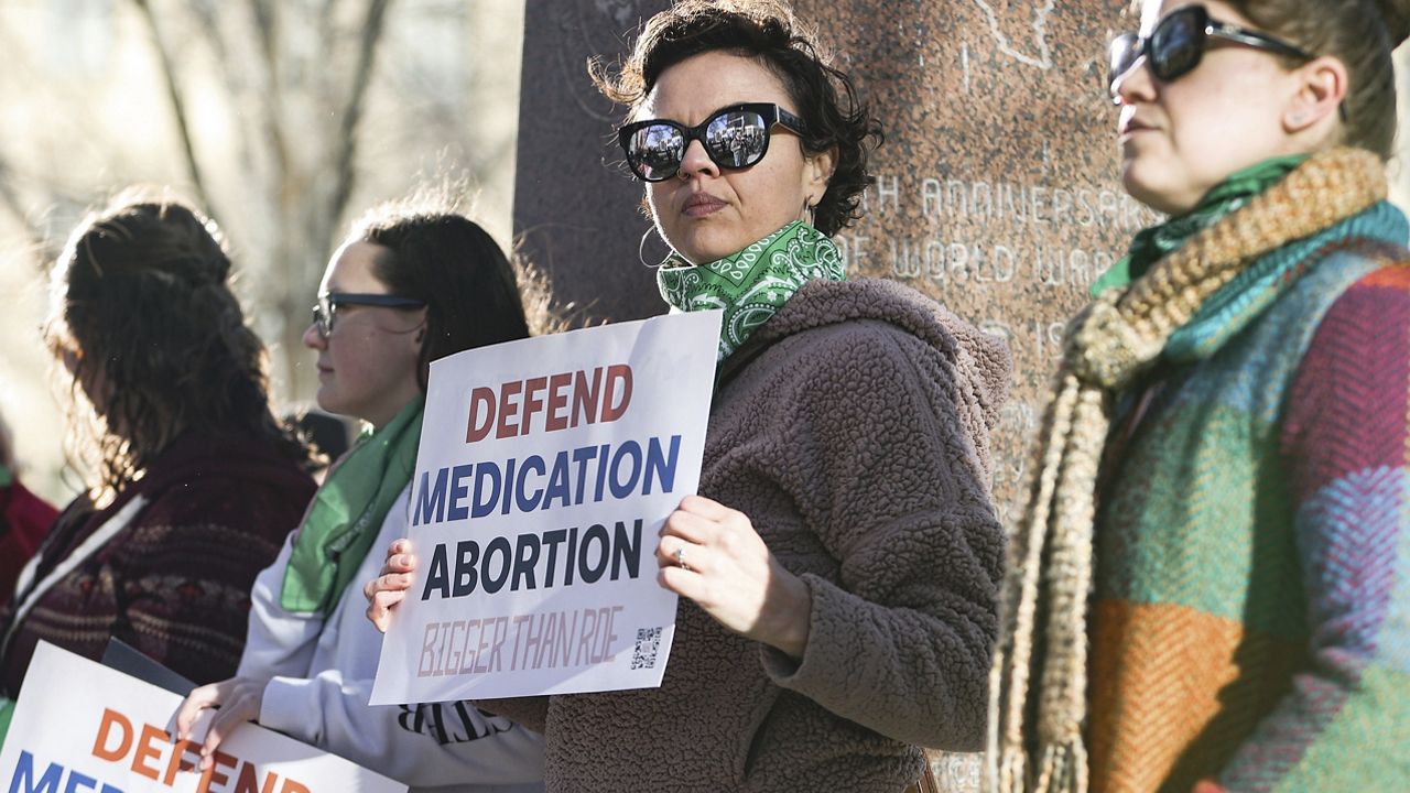 Lindsay London holds protest sign in front of federal court building in support of access to abortion medication outside the Federal Courthouse on Wednesday, March 15, 2023 in Amarillo, Texas. (AP Photo/David Erickson)