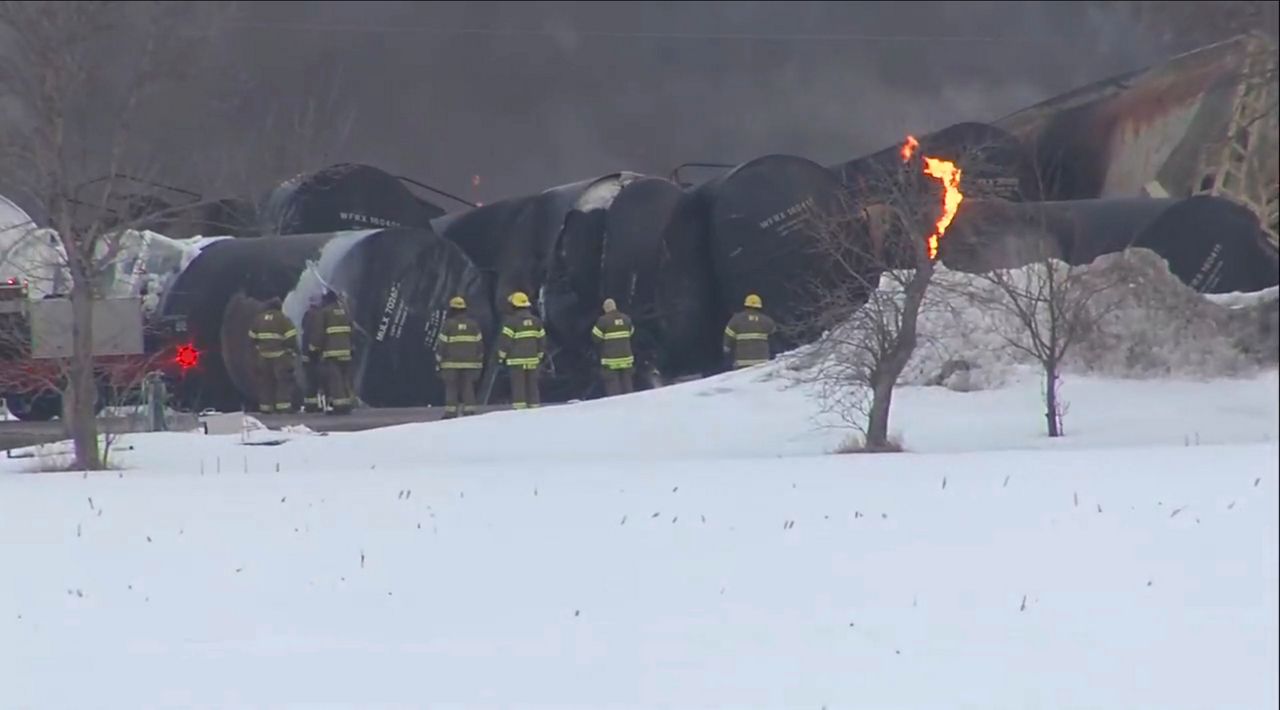 In this photo provided by KSTP, emergency personnel respond to the scene of a train derailment early Thursday, March 30, 2023 in Raymond, Min. A train hauling ethanol and corn syrup derailed and caught fire and nearby residents were ordered to evacuate their homes, authorities said. (KSTP via AP