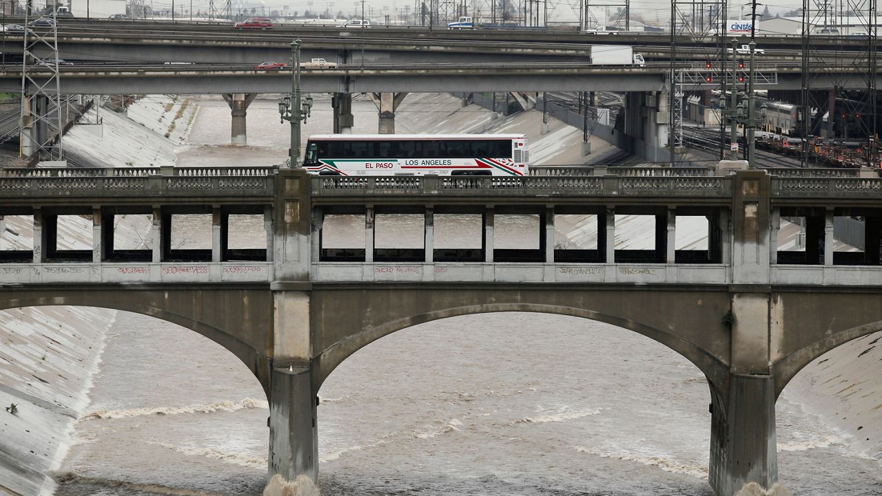  In this Dec. 22, 2010, file photo, traffic moves above bridges across the Los Angeles River carrying a high volume of water.(AP Photo/Damian Dovarganes, File)