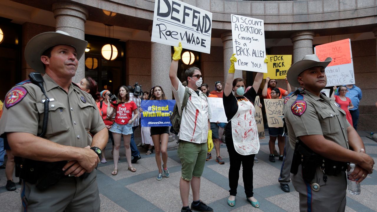 Opponents and supporters of an abortion bill gather in a courtyard outside a hearing for the bill at the Texas State Capitol, Tuesday, July 2, 2013, in Austin. AP Photo/Eric Gay)