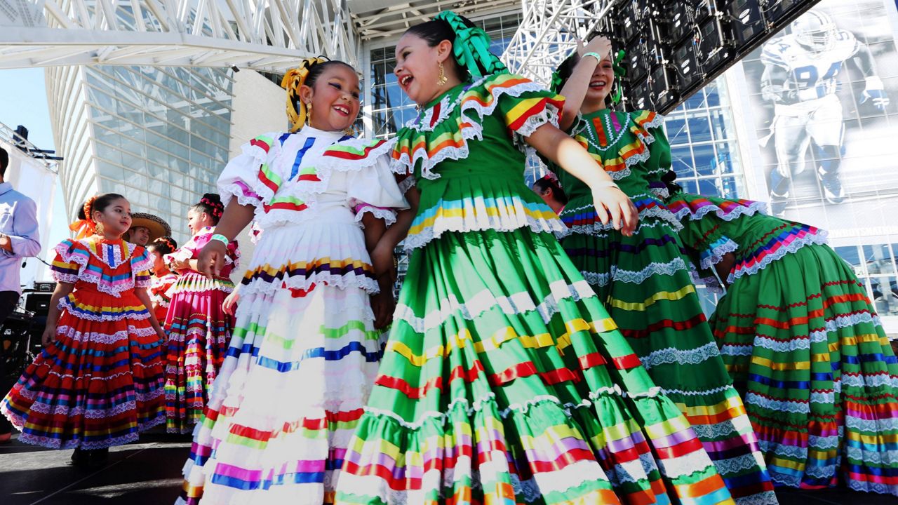 Members of a ballet folklorico dance troupe gather onstage before of an NFL football in Arlington, Texas. (AP Photo/LM Otero)