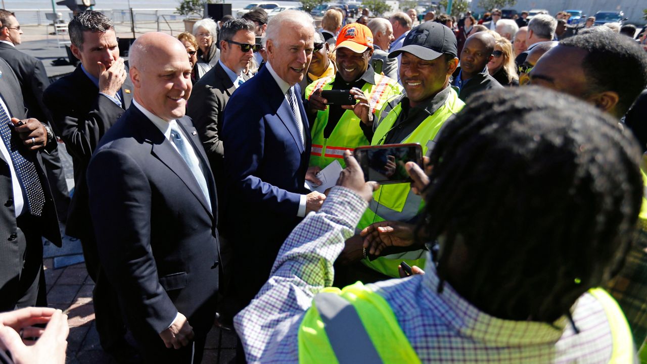 FILE: Vice President Joe Biden, center, and New Orleans Mayor Mitch Landrieu, left, greet longshoremen after speaking and touring the Port of New Orleans to commemorate the seventh anniversary of the American Recovery and Reinvestment Act in New Orleans, Wednesday, Feb. 17, 2016. (AP Photo/Gerald Herbert)