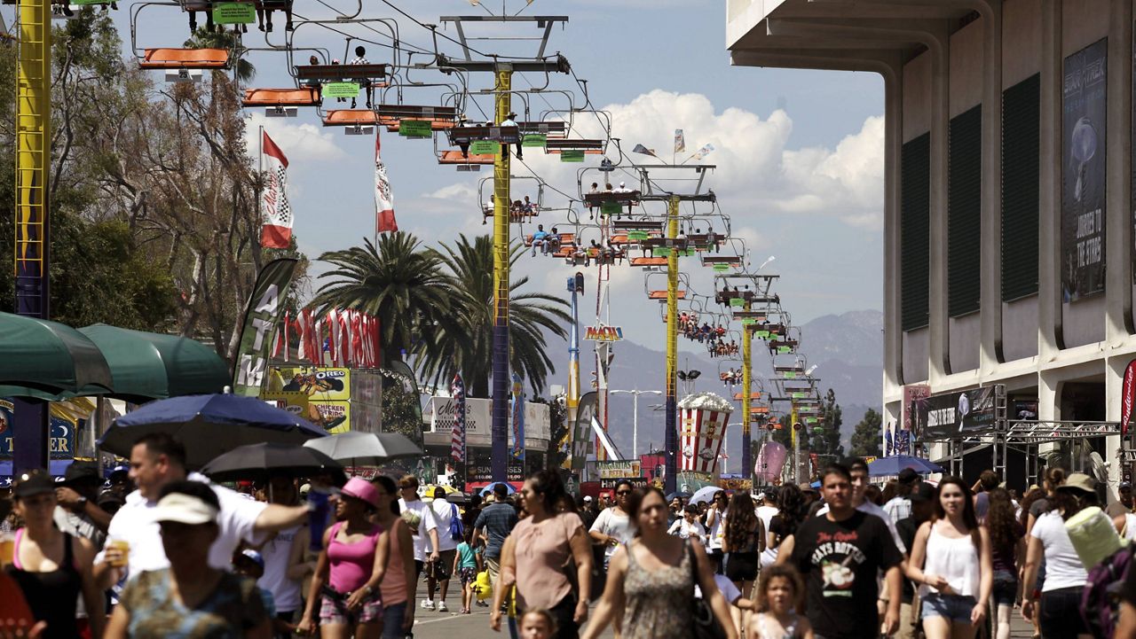Fairgoers ride a tram over the crowds at the LA County Fair celebrating Labor Day in Pomona Calif. on Monday Sept. 2, 2013. (AP Photo/Richard Vogel)