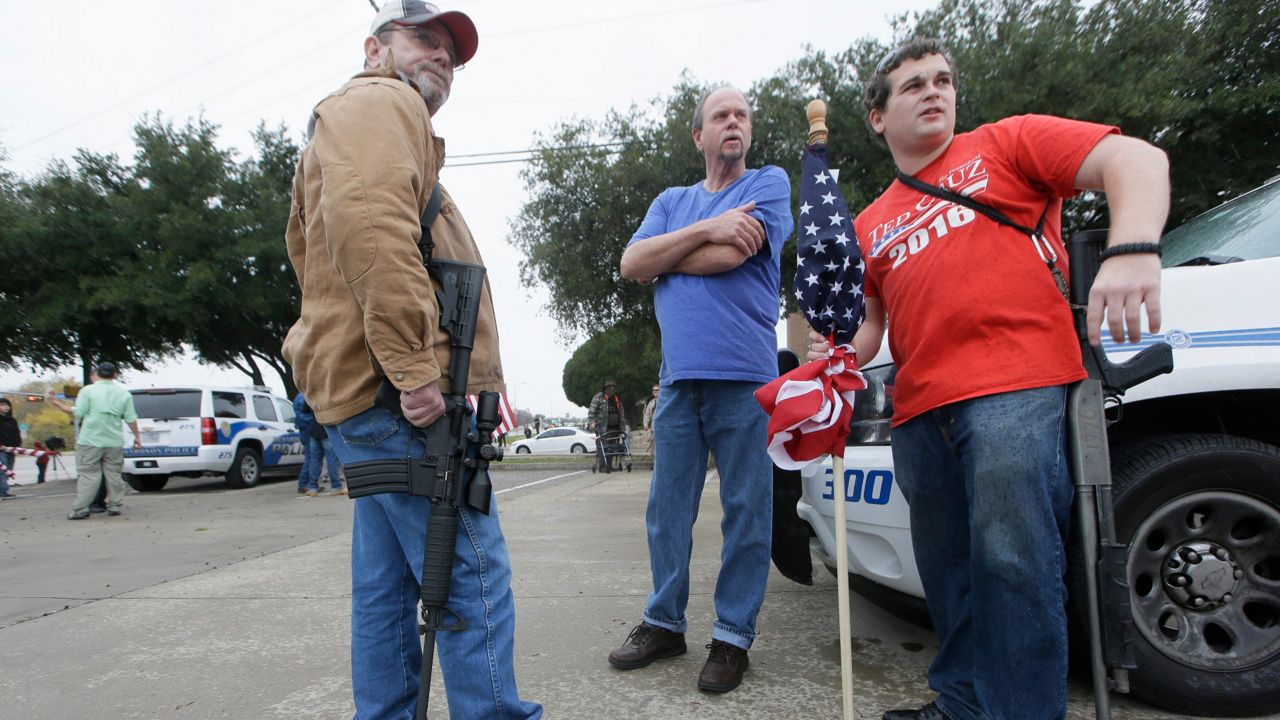 Armed anti-Muslim protestors, who did not want to give their names, prepare to take a position across the street from a mosque in Richardson, Texas on Saturday, Dec. 12, 2015. (AP Photo/LM Otero)