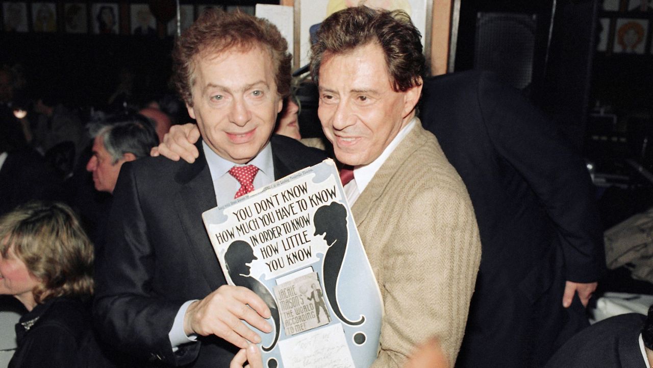 Jackie Mason, left, poses with Eddie Fisher during a reopening party at Sardi's restaurant in New York, May 3, 1988 following Mason's own reopening in the show "The World According To Me," on Broadway. (AP Photo/Ray Stubblebine)