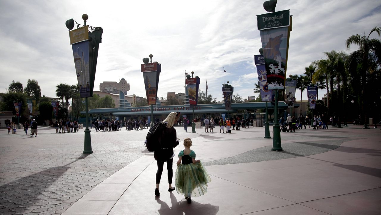 Visitors arrive at the main entrance to the Disney theme parks, Thursday, Jan. 22, 2015, in Anaheim, Calif. (AP Photo/Jae C. Hong)