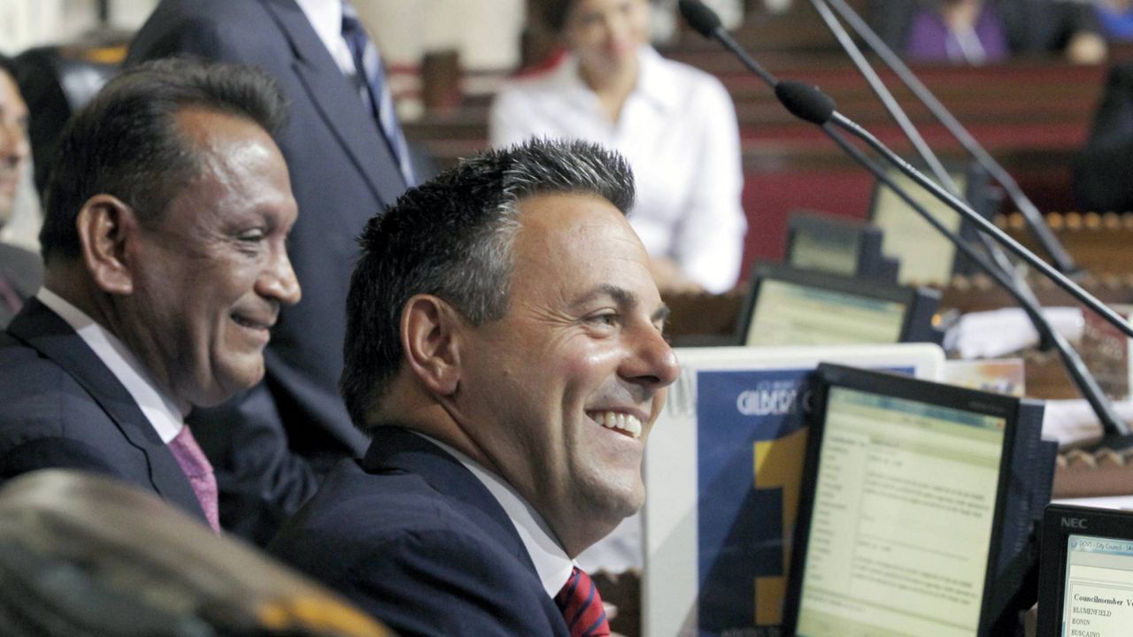 Los Angeles City Councilman Gilbert Cedillo, left, and Councilman Joe Buscaino smile after a city council vote in L.A., Sept. 1, 2015. (AP Photo/Nick Ut)