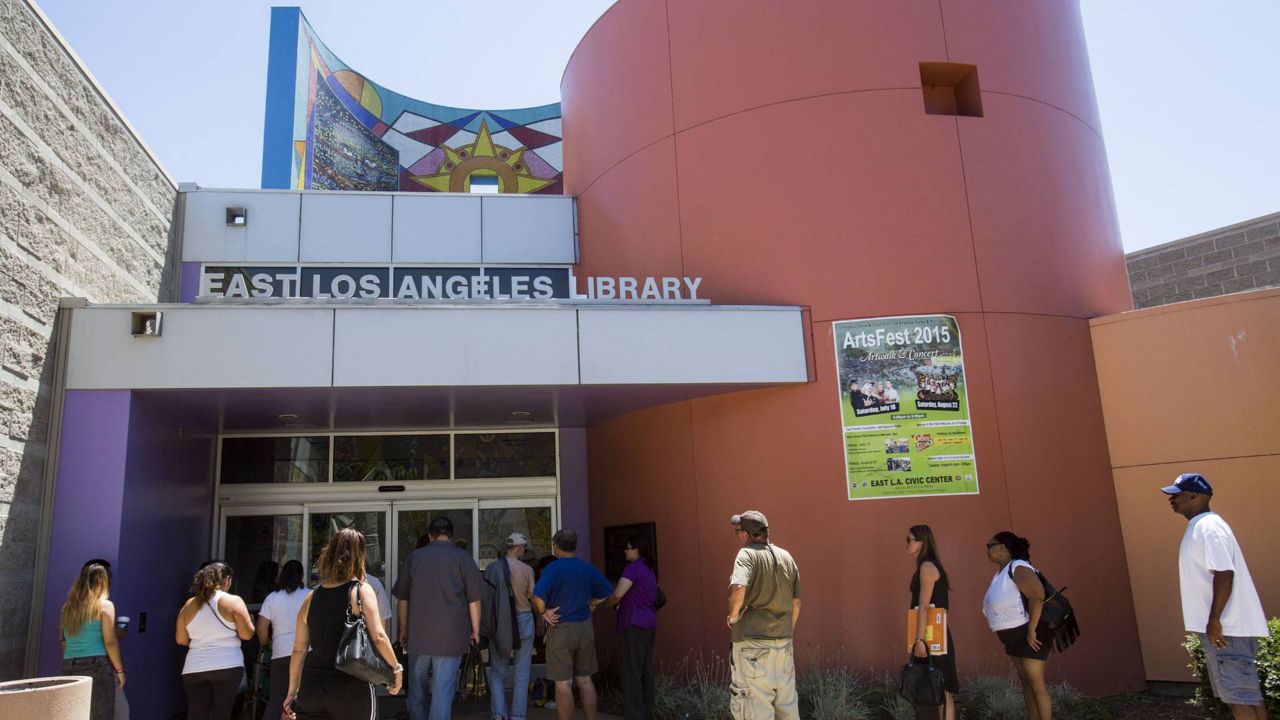 People wait to enter the East Los Angeles Library to escape the heat, Aug. 16, 2015. (AP Photo/Ringo H.W. Chiu)