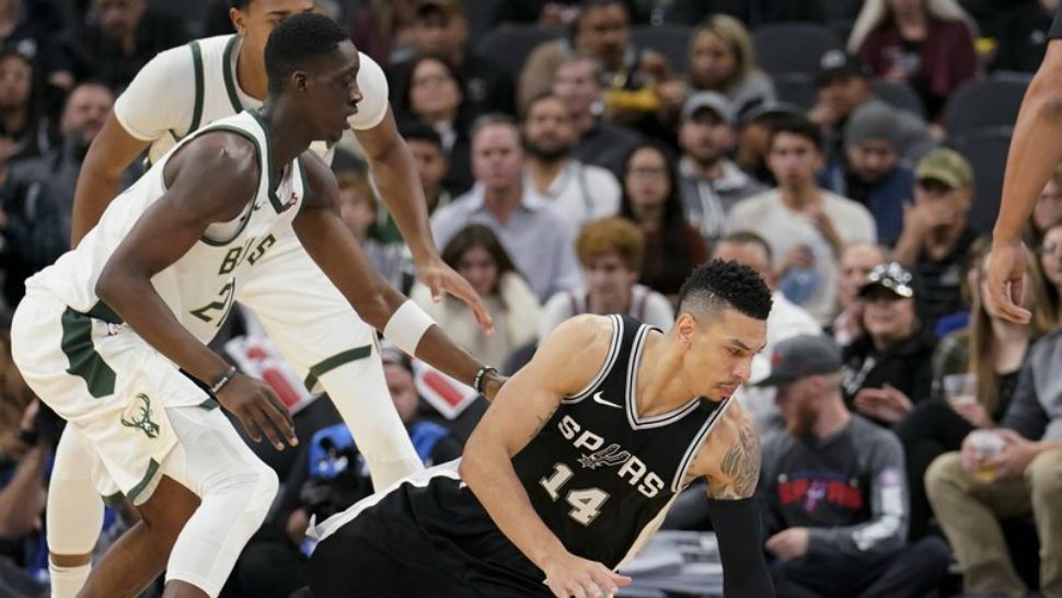 San Antonio Spurs guard Danny Green falls as he chases the ball next to Milwaukee Bucks guard Tony Snell during the first half of an NBA basketball game, Friday, Nov. 10, 2017 in San Antonio. (AP Photo/Darren Abate)