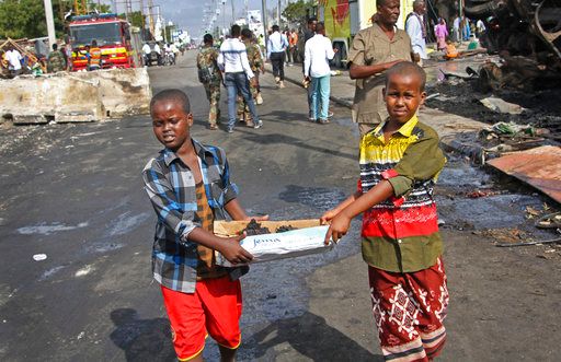 Niños somalis ayudan en la remoción de escombros y búsqueda de víctimas de la explosión.