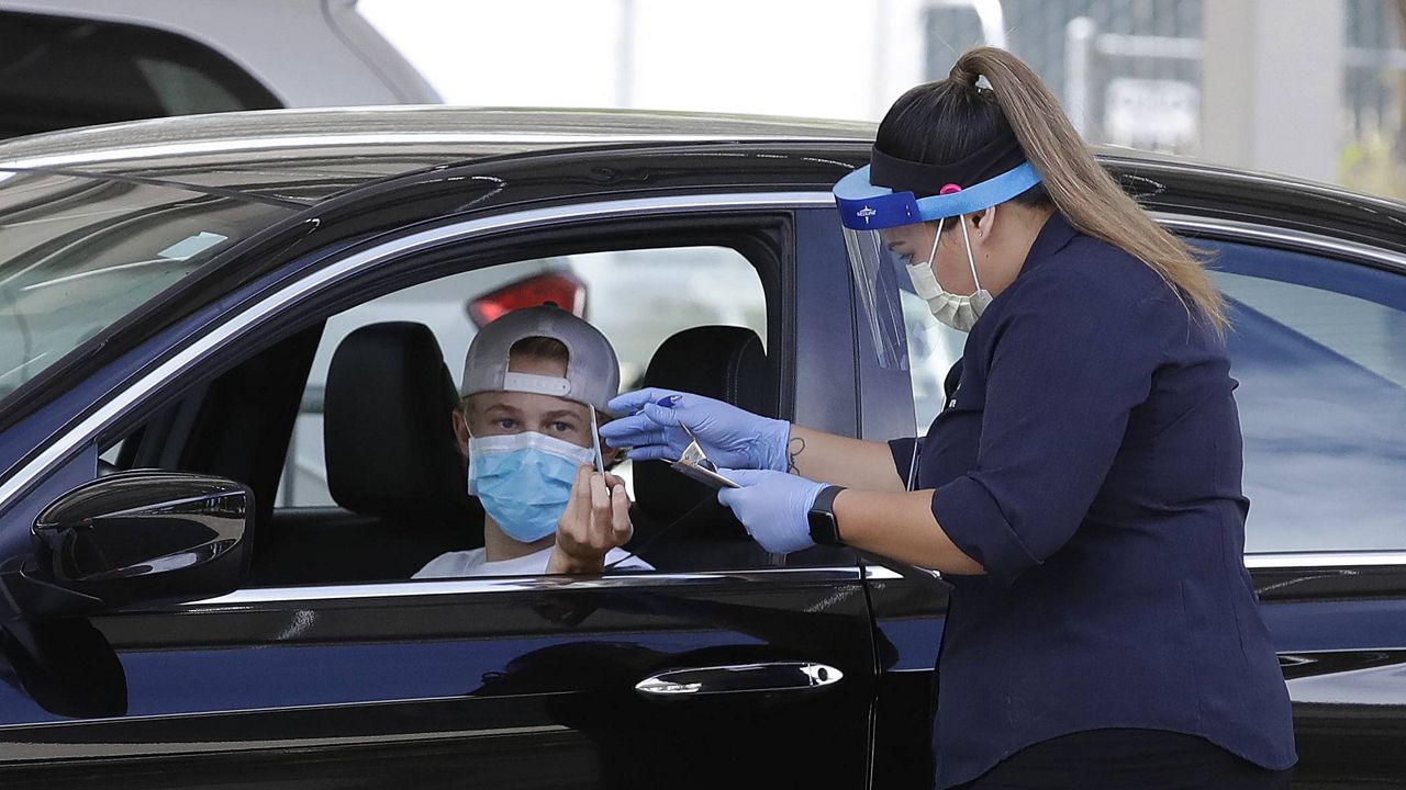 A healthcare worker takes information from a person at a Covid-19 testing center on Tuesday, July 21, 2020, in Pleasanton, Calif. (AP Photo/Ben Margot)