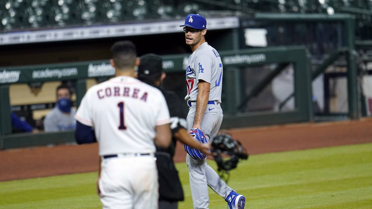 Los Angeles Dodgers relief pitcher Joe Kelly (17) talks toward Houston Astros' Carlos Correa (1) after the sixth inning of a baseball game Tuesday, July 28, 2020, in Houston. Kelly received an eight-game suspension for his actions after he threw a pitch in the area of the head of Houston Astros' Alex Bregman and later taunted Correa, which led to the benches clearing. (AP Photo/David J. Phillip)