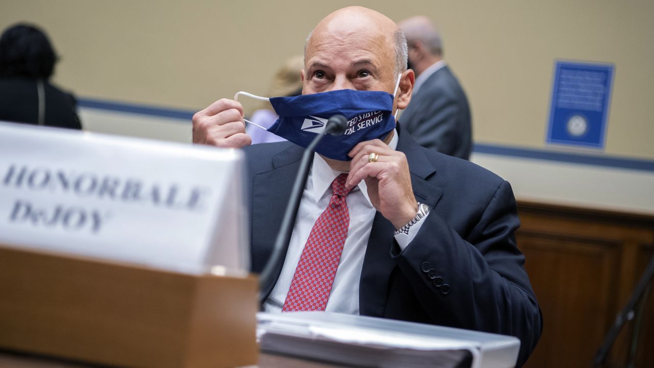 Postmaster General Louis DeJoy removes his face mask as he arrives to testify before a House Oversight and Reform Committee hearing on the Postal Service on Capitol Hill, Monday, Aug. 24, 2020, in Washington. (Tom Williams/Pool via AP)