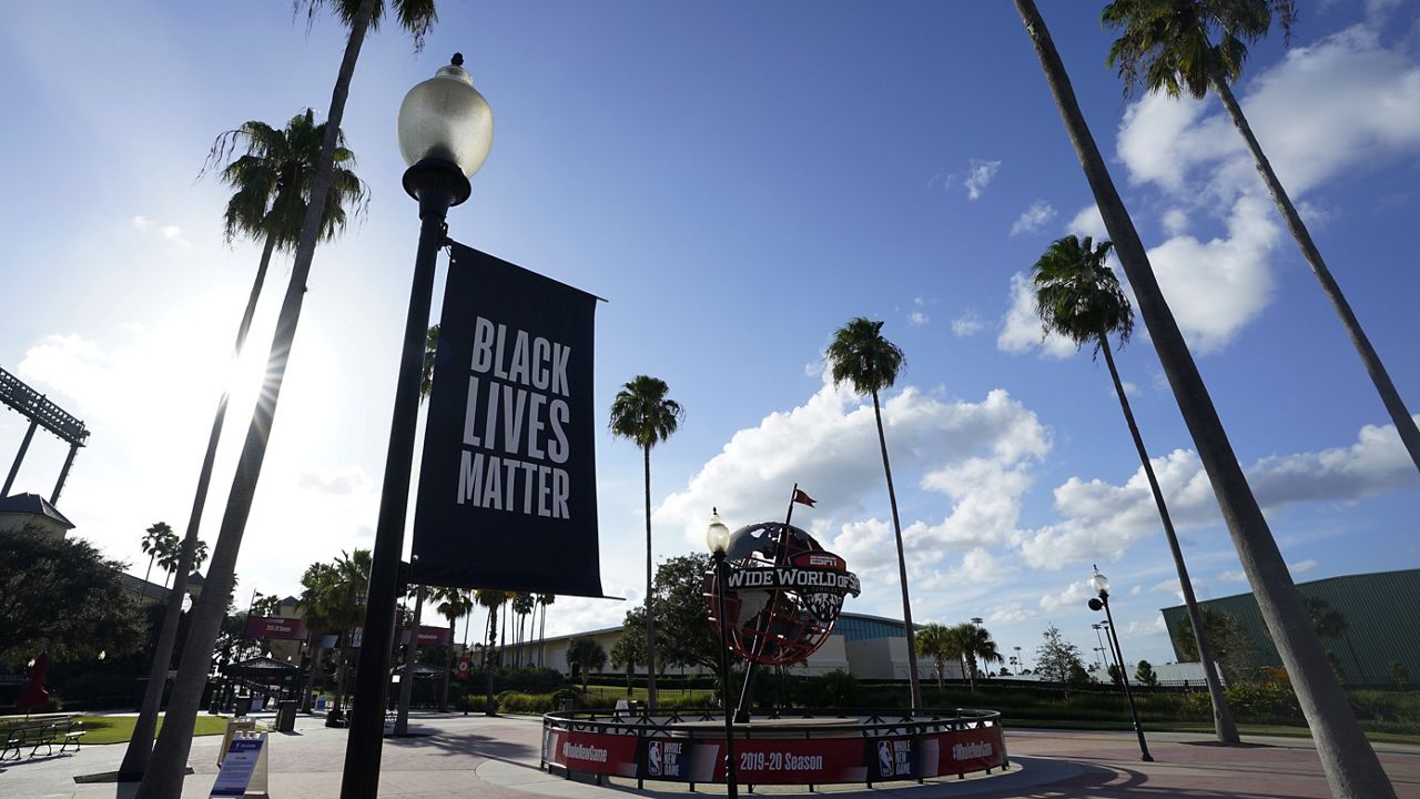 A Black Lives Matter banner hangs outside of the arena after a postponed NBA basketball first round playoff game between the Milwaukee Bucks and the Orlando Magic, Wednesday, Aug. 26, 2020, in Lake Buena Vista, Fla. (AP Photo/Ashley Landis, Pool)