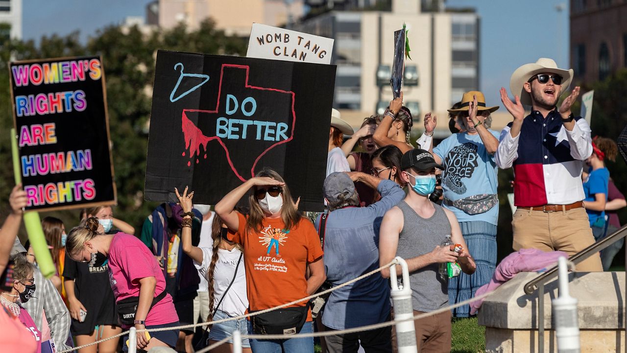 FILE - In this Oct. 2, 2021 file photo, people attend the Women's March ATX rally, at the Texas State Capitol in Austin, Texas. A federal judge has ordered Texas to suspend a new law that has banned most abortions in the state since September. The order Wednesday, Oct. 6, by U.S. District Judge Robert Pitman freezes for now the strict abortion law known as Senate Bill 8. (AP Photo/Stephen Spillman, File)