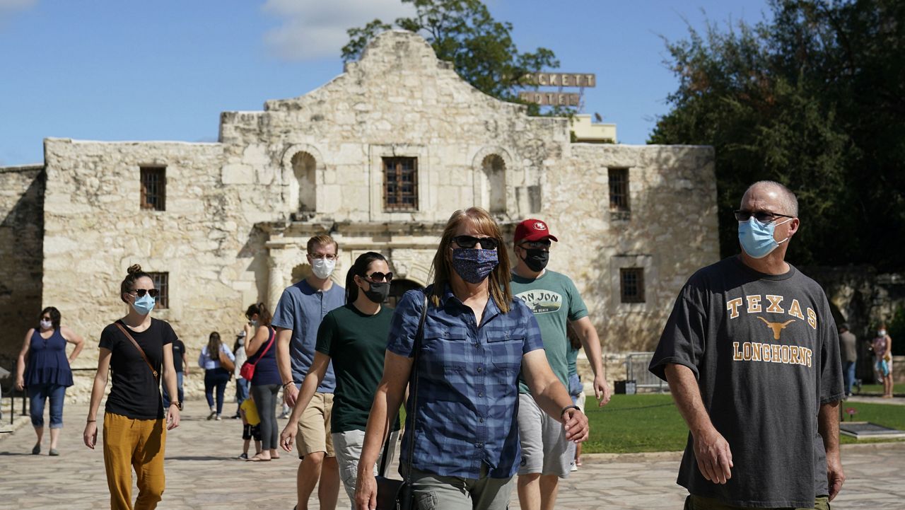 FILE - Visitors wearing masks for protection from COVID-19 leave the recently reopened Alamo, Tuesday, Sept. 22, 2020, in San Antonio. (AP Photo/Eric Gay)