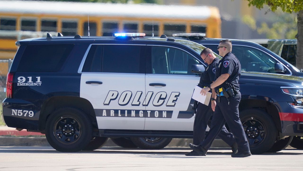 Law enforcement officers walk in the parking lot of Timberview High School after a shooting inside the school located in south Arlington, Texas, Wednesday, Oct. 6, 2021. (AP Photo/LM Otero)
