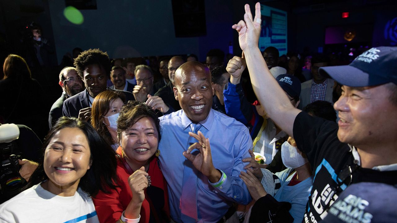 Bernard Adams, center, brother of New York mayoral candidate Eric Adams, mingles with supporters at an election party, late Tuesday, June 22, 2021, in New York. (AP Photo/Kevin Hagen)