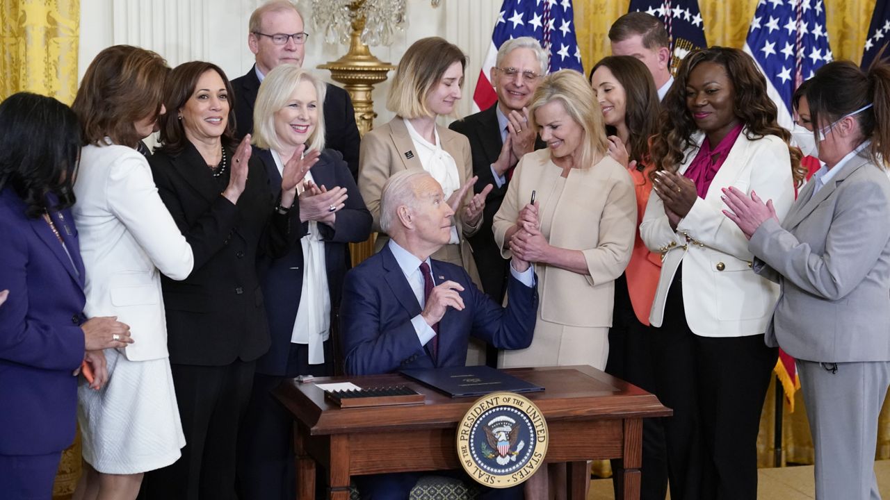 President Joe Biden hands a pen to Gretchen Carlson after signing a bill to end forced arbitration in sexual harassment cases in the workplace, Thursday, March 3, 2022, in the East Room of the White House in Washington. (AP Photo/Patrick Semansky)