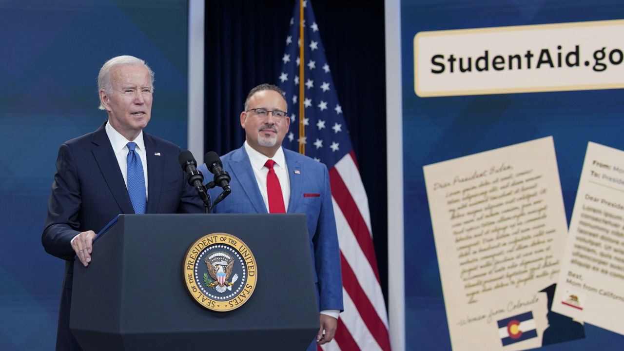 President Joe Biden speaks about the student debt relief portal beta test as Education Secretary Miguel Cardona listens in the South Court Auditorium on the White House complex in Washington, Monday, Oct. 17, 2022. (AP Photo/Susan Walsh)