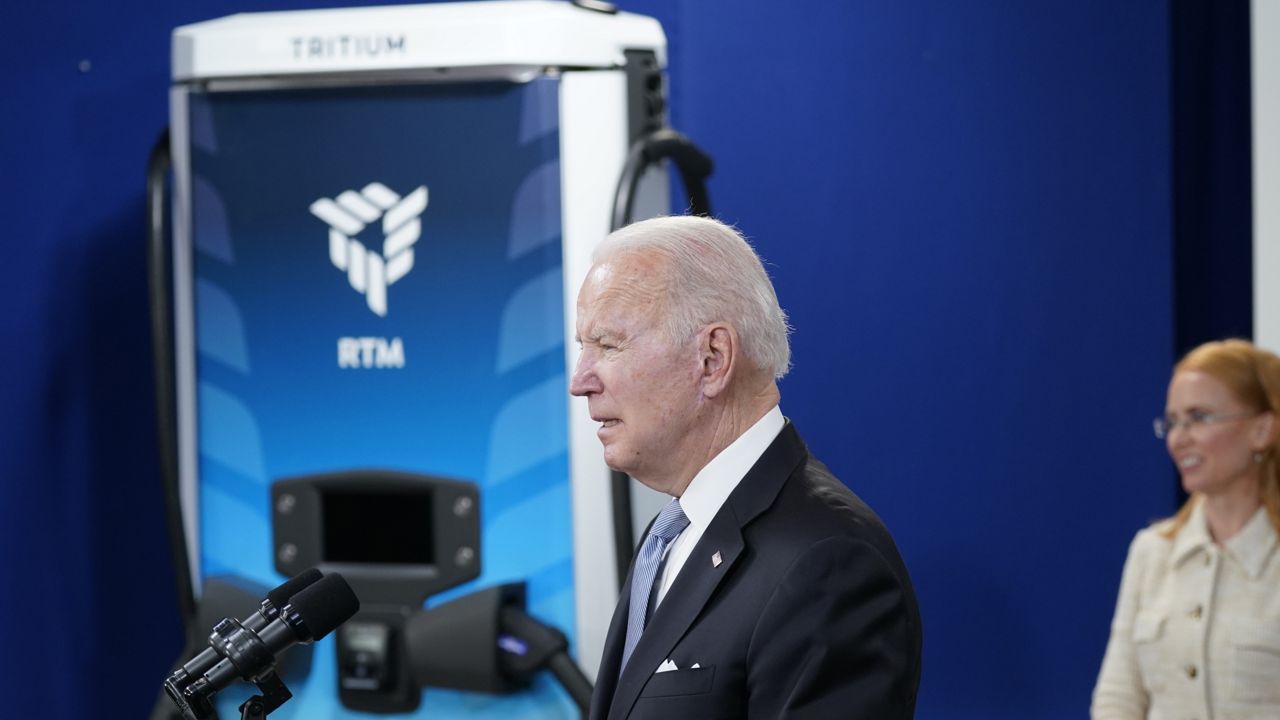 With a Tritium electric vehicle charger in the background, President Joe Biden speaks about electric vehicles during an event in the South Court Auditorium in the Eisenhower Executive Office Building on the White House complex, Tuesday, Feb. 8, 2022, in Washington. Jane Hunter, CEO of Tritium, listens at right. (AP Photo/Alex Brandon)