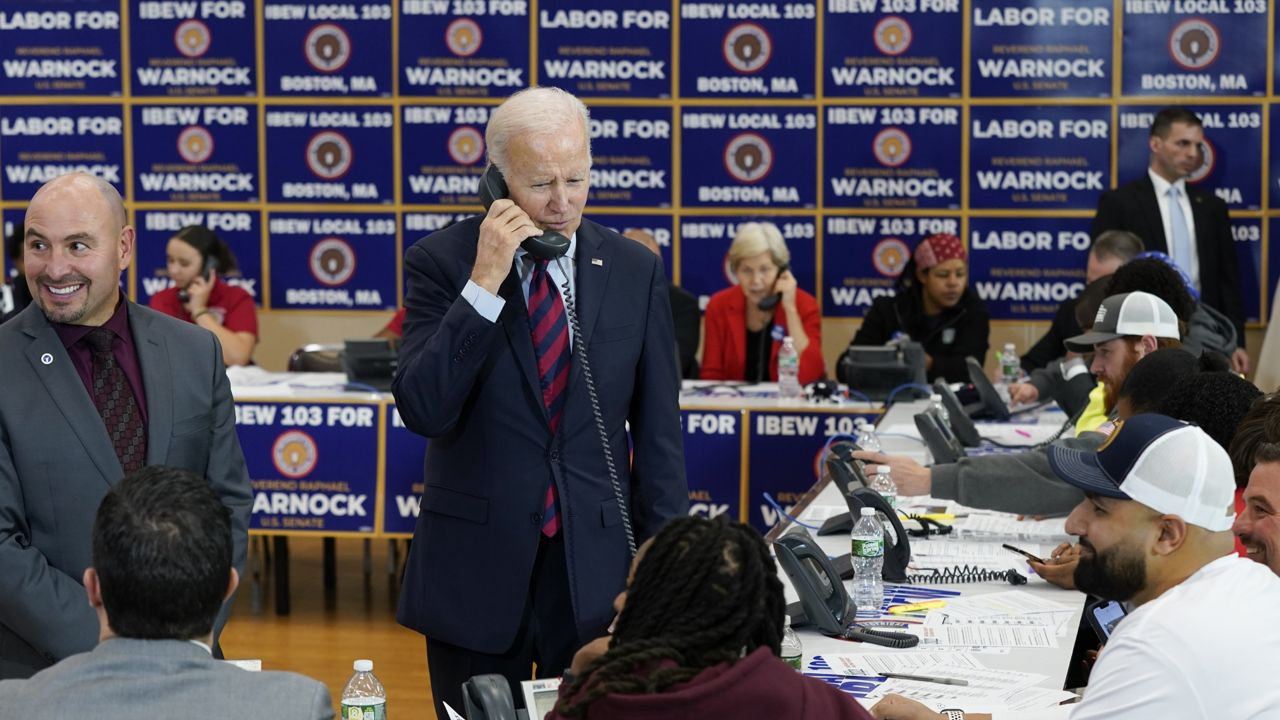 President Joe Biden speaks on the phone while visiting a phone bank at International Brotherhood of Electrical Workers Local 103, Friday, Dec. 2, 2022, in Boston. (AP Photo/Patrick Semansky)