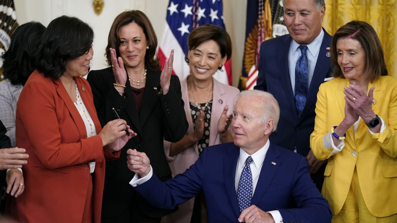 President Joe Biden hands a pen to Rep. Grace Meng, D-N.Y., after signing the "Commission To Study the Potential Creation of a National Museum of Asian Pacific American History and Culture Act," Monday, June 13, 2022, in the East Room of the White House in Washington. (AP Photo/Patrick Semansky)