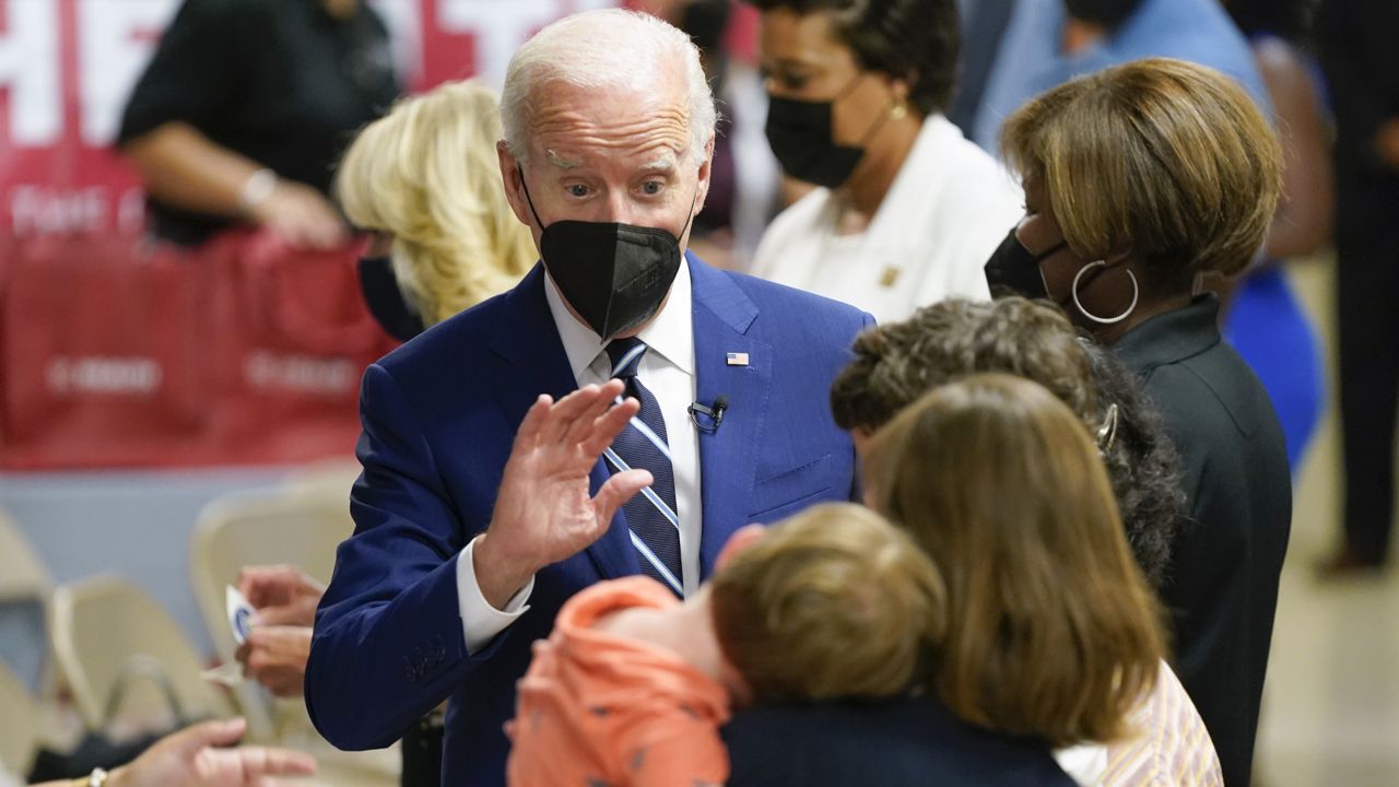 President Joe Biden waves to a child as he visits a COVID-19 vaccination clinic at the Church of the Holy Communion Tuesday, June 21, 2022, in Washington. (AP Photo/Evan Vucci)