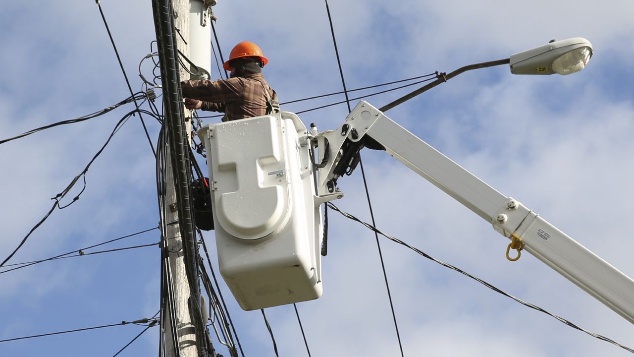 A crew from MIDTEL, a telecommunications service provider, splices a fiber service terminal for an upcoming customer installation on Friday, Dec. 3, 2021 in rural Berne, N.Y. (AP Photo/Michael Hill)