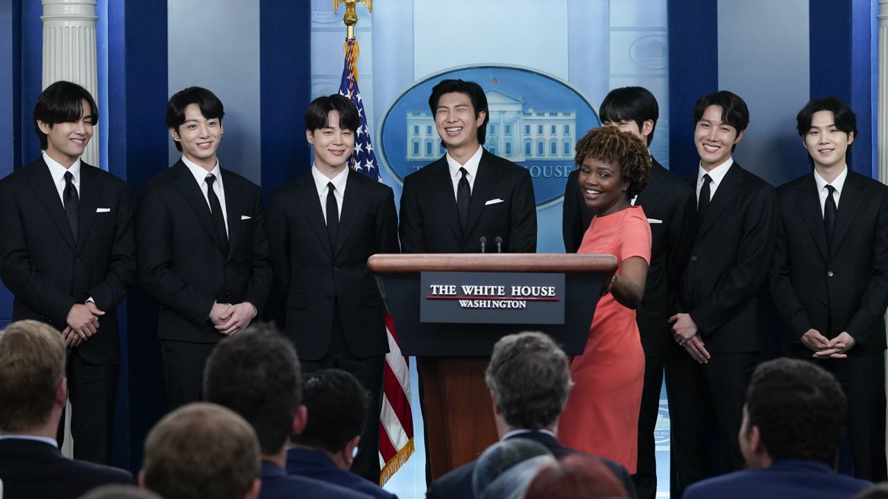Members of the K-pop supergroup BTS from left, V, Jungkook, Jimin, RM, Jin, J-Hope, and Suga join White House press secretary Karine Jean-Pierre during the daily briefing at the White House, Tuesday, May 31, 2022, in Washington. (AP Photo/Evan Vucci)