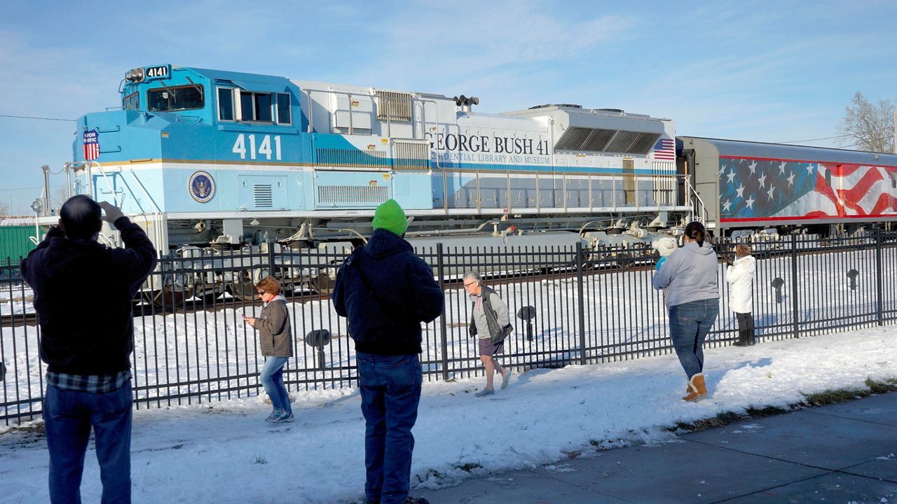 Spectators visit Union Pacific locomotive 4141, George H.W. Bush's funeral train, on a stop in Omaha, Neb., Monday, Dec. 10, 2018. (AP Photo/Nati Harnik)