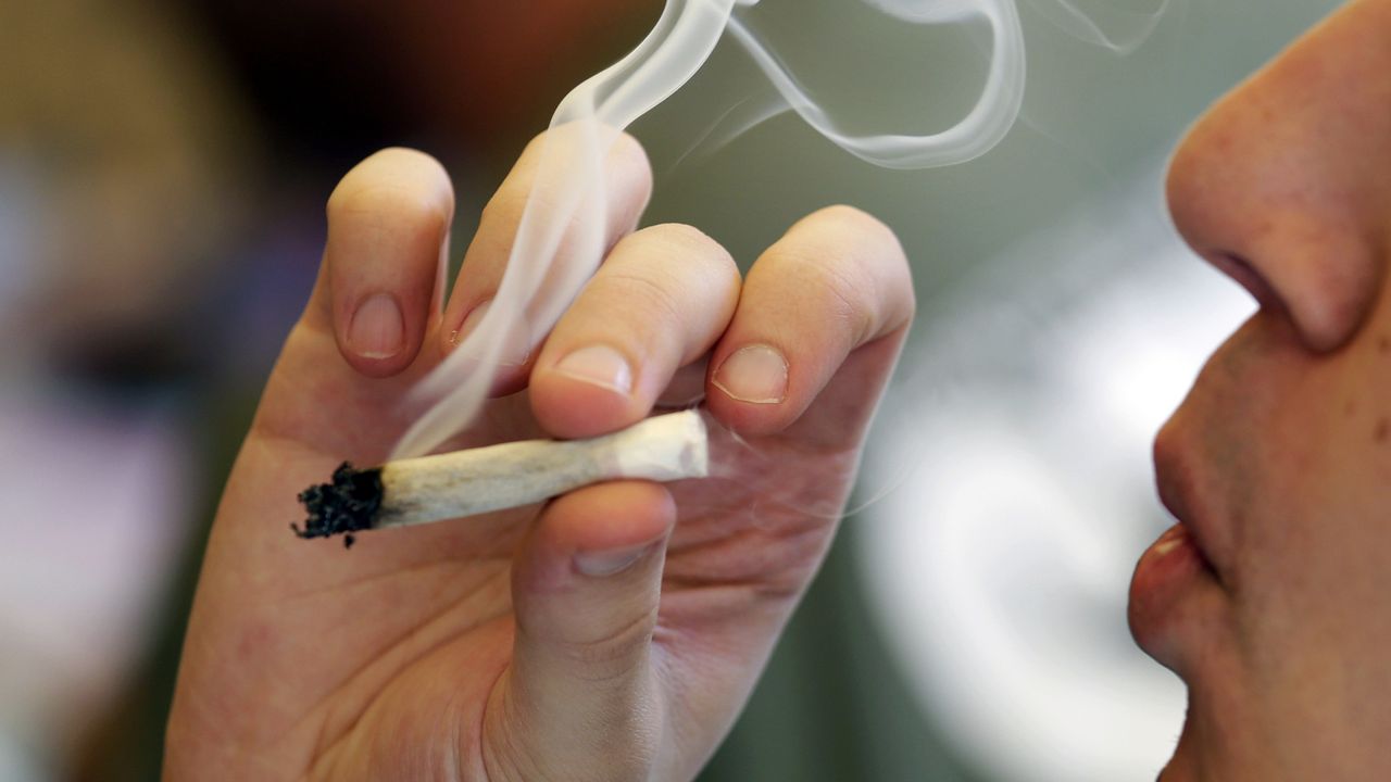 FILE - In this April 20, 2016, file photo, a man smokes a marijuana joint at a party celebrating weed in Seattle. (AP Photo/Elaine Thompson, File)