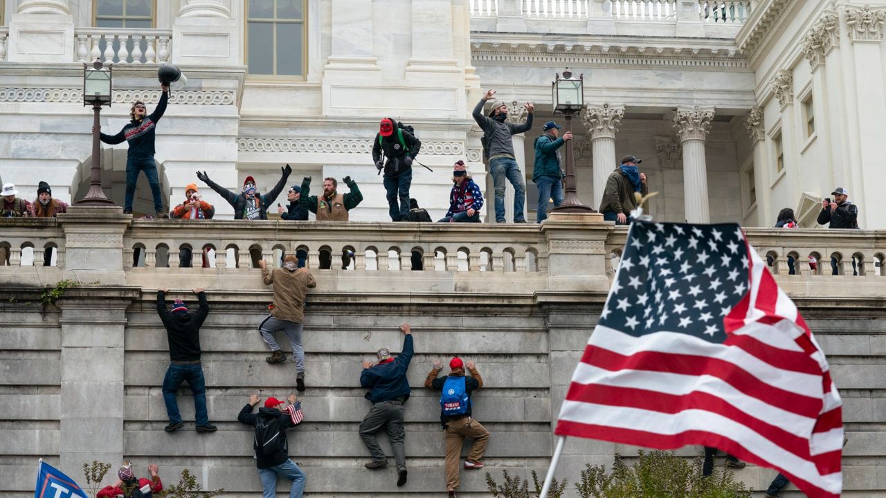 Rioters climb a wall at the U.S. Capitol in this image from Jan. 6. 2021. (AP Photo)