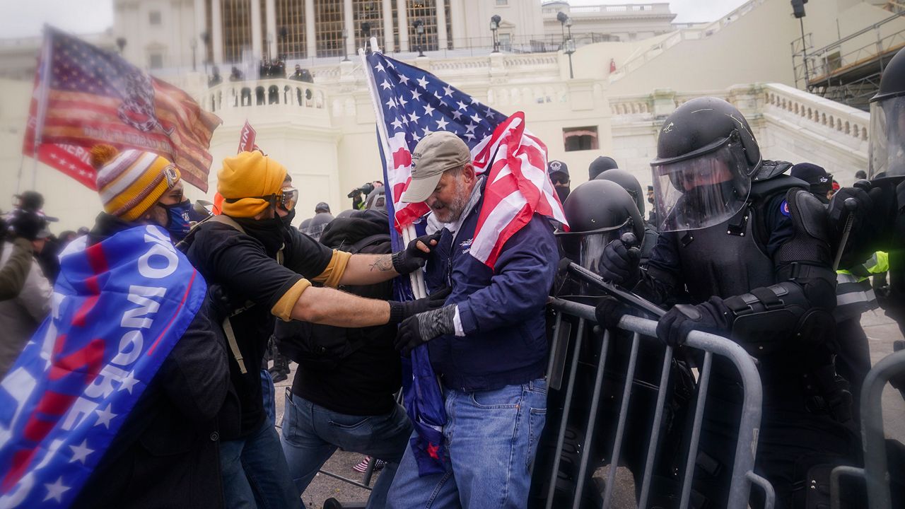 In this Jan. 6, 2021, file photo, rioters try to break through a police barrier at the Capitol in Washington. (AP Photo/John Minchillo)