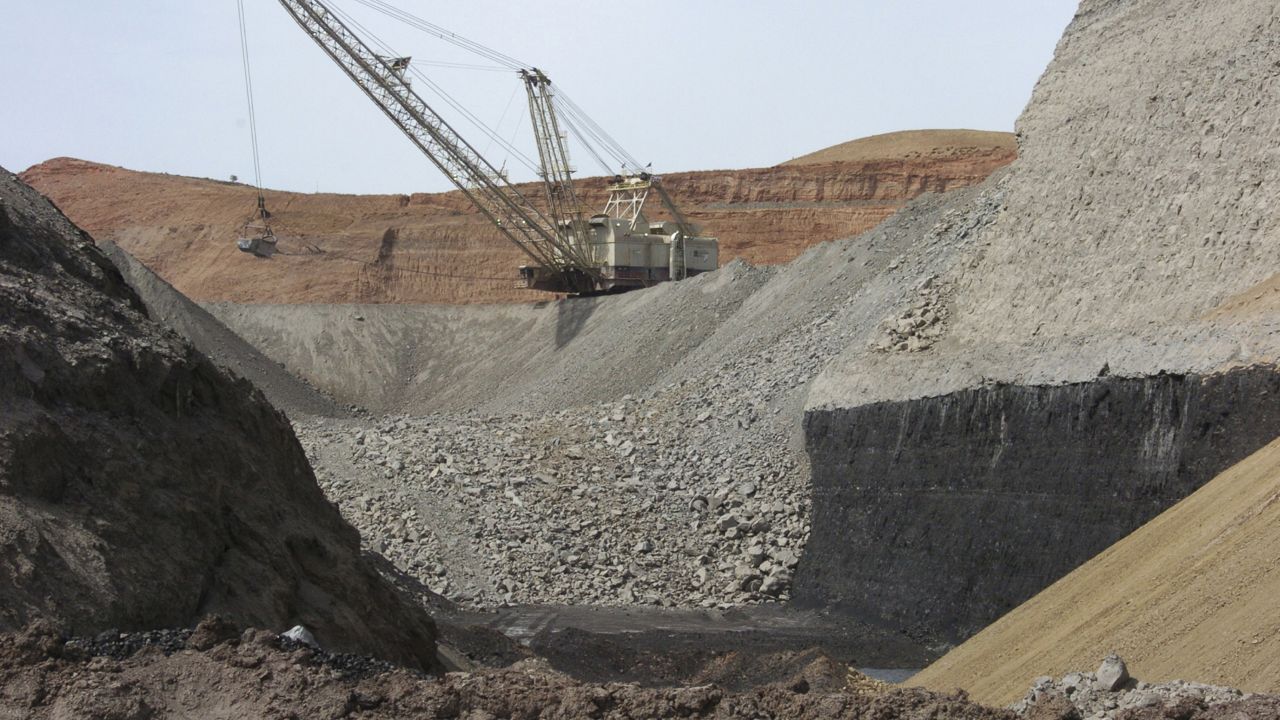 In this April 4, 2013, file photo, a dragline excavator moves rocks above a coal seam at the Spring Creek Mine in Decker, Mont. (AP Photo/Matthew Brown, File)
