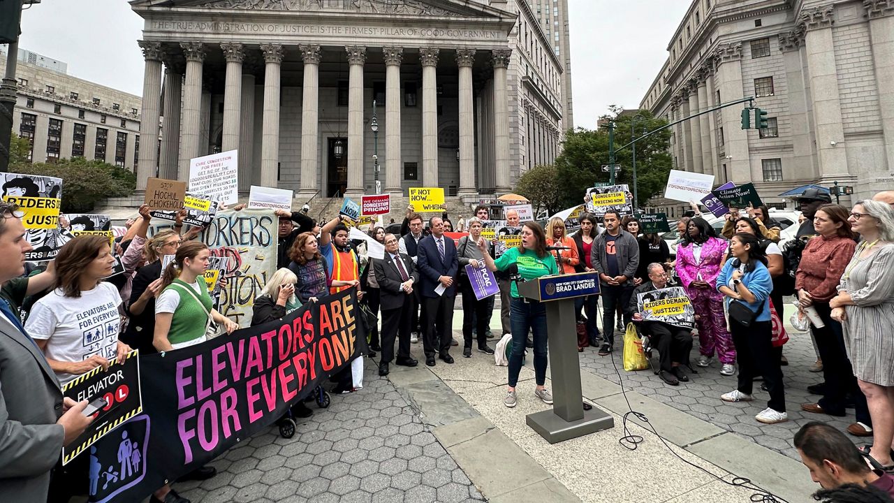 A photo of advocates protesting outside a Manhattan courthouse ahead of a hearing on congestion pricing.