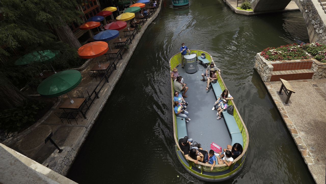 Using social distancing and other protective measures against COVID-19, visitors ride a river barges along the River Walk in San Antonio, Monday, June 15, 2020, in San Antonio. (AP Photo/Eric Gay)