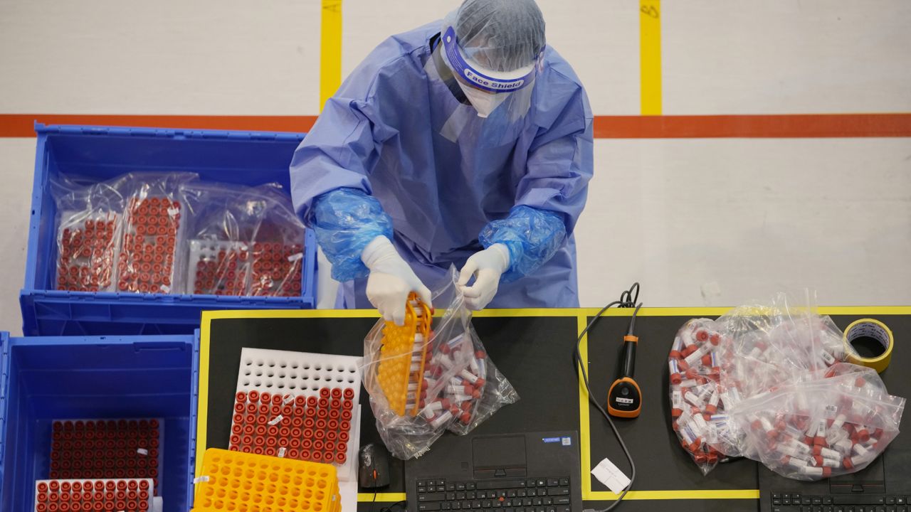 FILE: A health worker from mainland China collects the samples from Hong Kong residents to be tested for the coronavirus at the Huo-Yan (Fire Eye) Laboratory, an inflatable mobile testing lab in Hong Kong, Friday, March 4, 2022. (AP Photo/Kin Cheung)