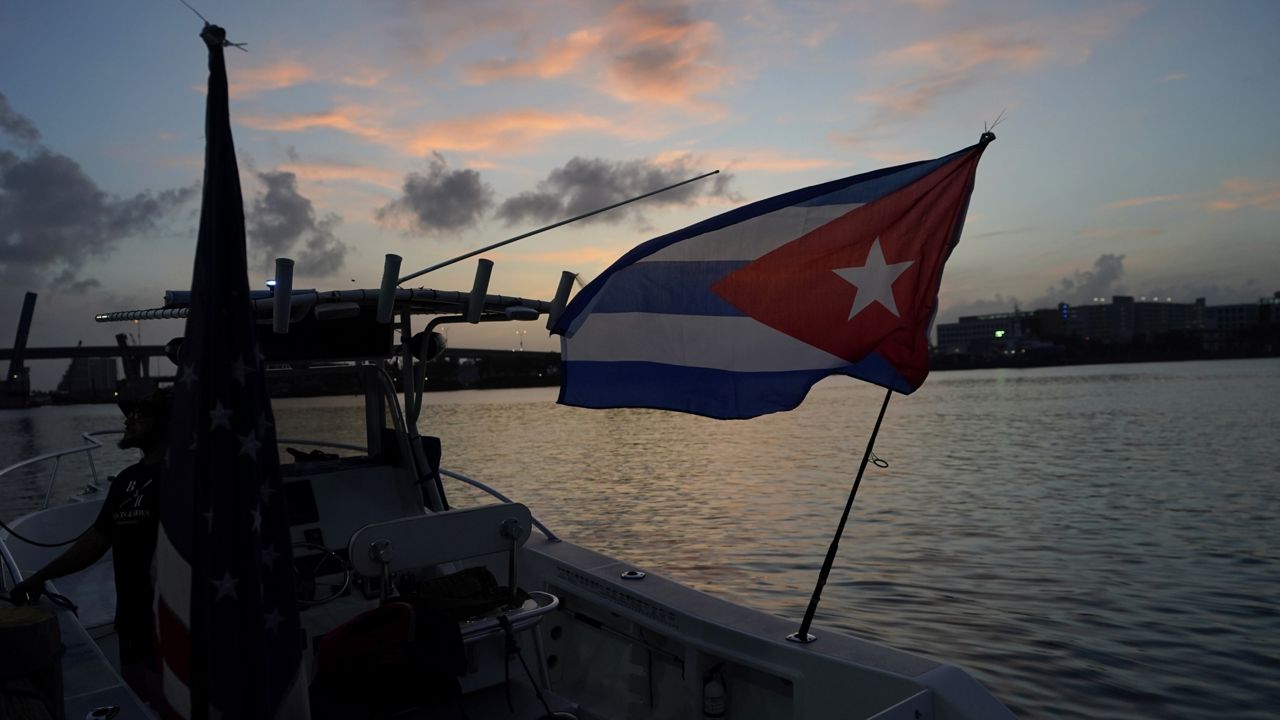 A boat flying Cuban and American flags is docked in the early morning hours, Friday, July 23, 2021, in downtown Miami. (AP Photo/Wilfredo Lee)